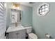 Updated powder room with gray vanity, marble countertop, and octagon window at 1423 Landings Pl # 59, Sarasota, FL 34231