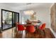 Elegant dining room with glass table, orange chairs, hardwood floors at 1423 Landings Pl # 59, Sarasota, FL 34231