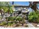 Front view of a two-story home showcasing a balcony and mature trees at 1423 Landings Pl # 59, Sarasota, FL 34231