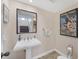 Elegant powder room with pedestal sink, mirror, and vintage art at 16 Tidy Island Blvd # 16, Bradenton, FL 34210