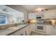 White kitchen with gray countertops and a pass-through to the living area at 1621 Clower Creek Dr # Tr173, Sarasota, FL 34231