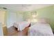 Bedroom with two twin beds and light green walls at 1801 Gulf N Dr # 175, Bradenton Beach, FL 34217