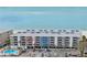 Aerial view of beachfront condo building with parking and pool at 19610 Gulf Blvd # 303, Indian Shores, FL 33785