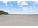 Wide sandy beach with ocean and shoreline buildings in the distance at 19610 Gulf Blvd # 303, Indian Shores, FL 33785