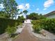 Landscaped backyard path leading to a detached structure at 1981 Bayshore Dr, Englewood, FL 34223