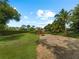 Large backyard with grassy area, hedgerows, and gravel pathways at 1981 Bayshore Dr, Englewood, FL 34223