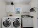 Bright laundry room with washer, dryer, and cabinets at 1981 Bayshore Dr, Englewood, FL 34223