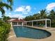 Inviting pool area with pergola, lush landscaping, and a spacious pool at 1981 Bayshore Dr, Englewood, FL 34223