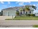 Two-story house with three-car garage, palm trees, and manicured lawn at 210 Beeney Se Rd, Port Charlotte, FL 33952