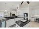 Modern kitchen with white cabinets, granite island, and built-in workspace at 210 Beeney Se Rd, Port Charlotte, FL 33952