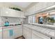 Galley kitchen with white cabinets, tile backsplash, and built-in appliances at 221 Tenacity Ln, Sarasota, FL 34242