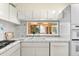 White kitchen features a pass-through window and tile counters at 221 Tenacity Ln, Sarasota, FL 34242