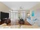 Living room with tiled floors, white couch, and large TV at 221 Tenacity Ln, Sarasota, FL 34242