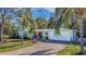 Light blue house with a paved driveway, palm trees, and a white picket fence at 2338 Lynn St, Sarasota, FL 34231