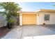 Attached garage with a yellow door and a paved driveway at 315 Palm Grove Ave, Englewood, FL 34223