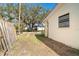 Side yard with wooden fence and a view of mature trees at 315 Palm Grove Ave, Englewood, FL 34223