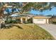 Single-story house with two-car garage and mature oak tree providing shade at 3298 Branch Creek Dr, Sarasota, FL 34235