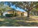 Single-story house with mature landscaping and large oak tree in the front yard at 3298 Branch Creek Dr, Sarasota, FL 34235