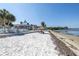 White sand beach with lounge chairs and thatch umbrella at 3640 41St S Ln # F, St Petersburg, FL 33711