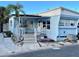 Light blue mobile home with covered porch, steps, and palm tree at 3710 Gulf Of Mexico Dr # G-6, Longboat Key, FL 34228