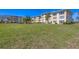 Well-maintained condominium building featuring lush green lawn and mature landscaping with several stories at 3810 Gulf Of Mexico Dr # F105, Longboat Key, FL 34228