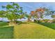 Expansive front yard showcasing mature trees and lush green grass with views of the water at 3810 Gulf Of Mexico Dr # F105, Longboat Key, FL 34228