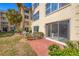 Brick paved patio with sliding glass doors to the condo, and lush tropical foliage at 3810 Gulf Of Mexico Dr # F105, Longboat Key, FL 34228