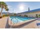 Community swimming pool and sundeck with lounge chairs offer a relaxing retreat with blue accents and palm trees at 3810 Gulf Of Mexico Dr # F105, Longboat Key, FL 34228