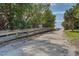 Picturesque sandy walkway framed by lush trees and green foliage, leading towards a serene beach destination at 3810 Gulf Of Mexico Dr # F105, Longboat Key, FL 34228