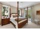 Charming bedroom with a four-poster bed and access to a private balcony at 3930 Red Rock Way, Sarasota, FL 34231