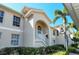 Tan two-story condo building with white trim, lush landscaping, and a stairway at 4250 Players Pl # 2625, Sarasota, FL 34238