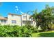 Back exterior showcasing a screened balcony and tropical foliage at 4250 Players Pl # 2625, Sarasota, FL 34238