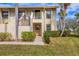 Two-story condo building with lush landscaping and palm trees at 4402 Weybridge St # 95, Sarasota, FL 34235