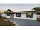 White single story home with teal shutters, landscaping, and a paved driveway at 4609 19Th W St, Bradenton, FL 34207