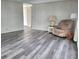 Bright living room featuring gray laminate flooring and a comfortable recliner at 4969 Pebble Beach Ave, Sarasota, FL 34234