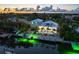 Aerial view of a waterfront home with a private pool and boat dock at dusk at 505 69Th St, Holmes Beach, FL 34217