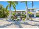 Two-story home showcasing a modern design, lush landscaping, and a two-car garage at 505 69Th St, Holmes Beach, FL 34217