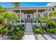 Modern home's front entrance with covered porch and lush landscaping at 505 69Th St, Holmes Beach, FL 34217