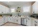 Clean kitchen with white cabinets, farmhouse sink, and quartz countertops at 505 69Th St, Holmes Beach, FL 34217