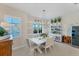 Bright dining area with white table and chairs, stylish light fixture, and built-in shelving at 5204 Title Row Dr, Bradenton, FL 34210