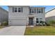 Two-story house with gray siding, stone accents, and a two-car garage at 5216 Adega Way, Bradenton, FL 34211