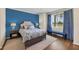 Bedroom with blue accent wall, hardwood floors, and a comfortable bed at 5517 Palmer Cir # 101, Bradenton, FL 34211