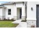 Modern front entry with stone accents and a dark gray front door at 5595 Delight Ave, North Port, FL 34288