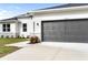 Two car garage with gray door and light gray concrete driveway at 5595 Delight Ave, North Port, FL 34288