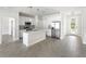 Open concept kitchen with island, stainless steel appliances, and white cabinets at 5595 Delight Ave, North Port, FL 34288