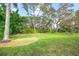 Landscaped backyard with lush greenery and large trees at 5826 Driftwood Pl # 34, Sarasota, FL 34231