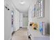 Bright and airy entryway with light flooring and coastal wall art at 5826 Driftwood Pl # 34, Sarasota, FL 34231