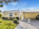 Quaint yellow home exterior with carport, landscaping and driveway at 5826 Driftwood Pl # 34, Sarasota, FL 34231