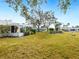 Community backyard with lush green grass and mature trees at 5936 Driftwood Ave # 16, Sarasota, FL 34231