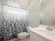 Bathroom with white vanity, toilet and patterned shower curtain at 5936 Driftwood Ave # 16, Sarasota, FL 34231